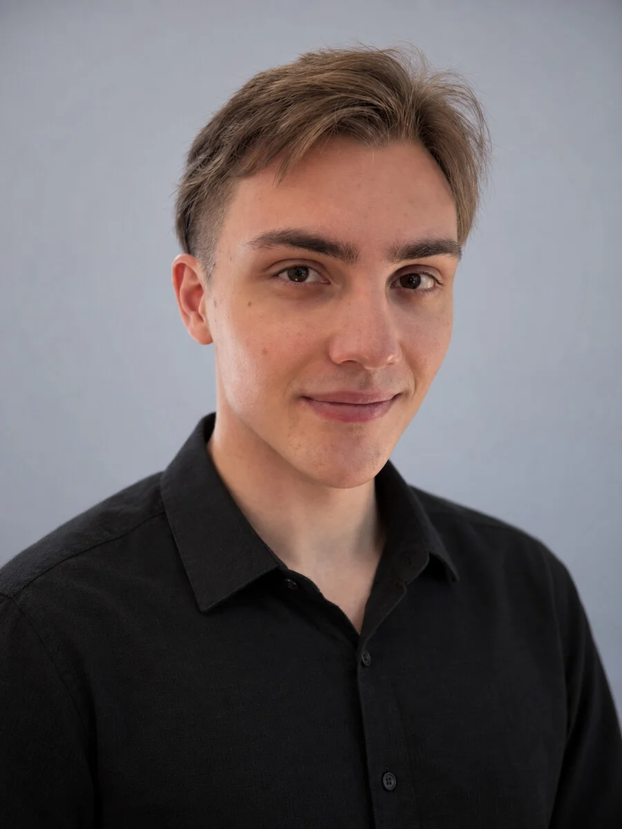 Porträt von Tom Begeng vor hellgrauem Hintergrund