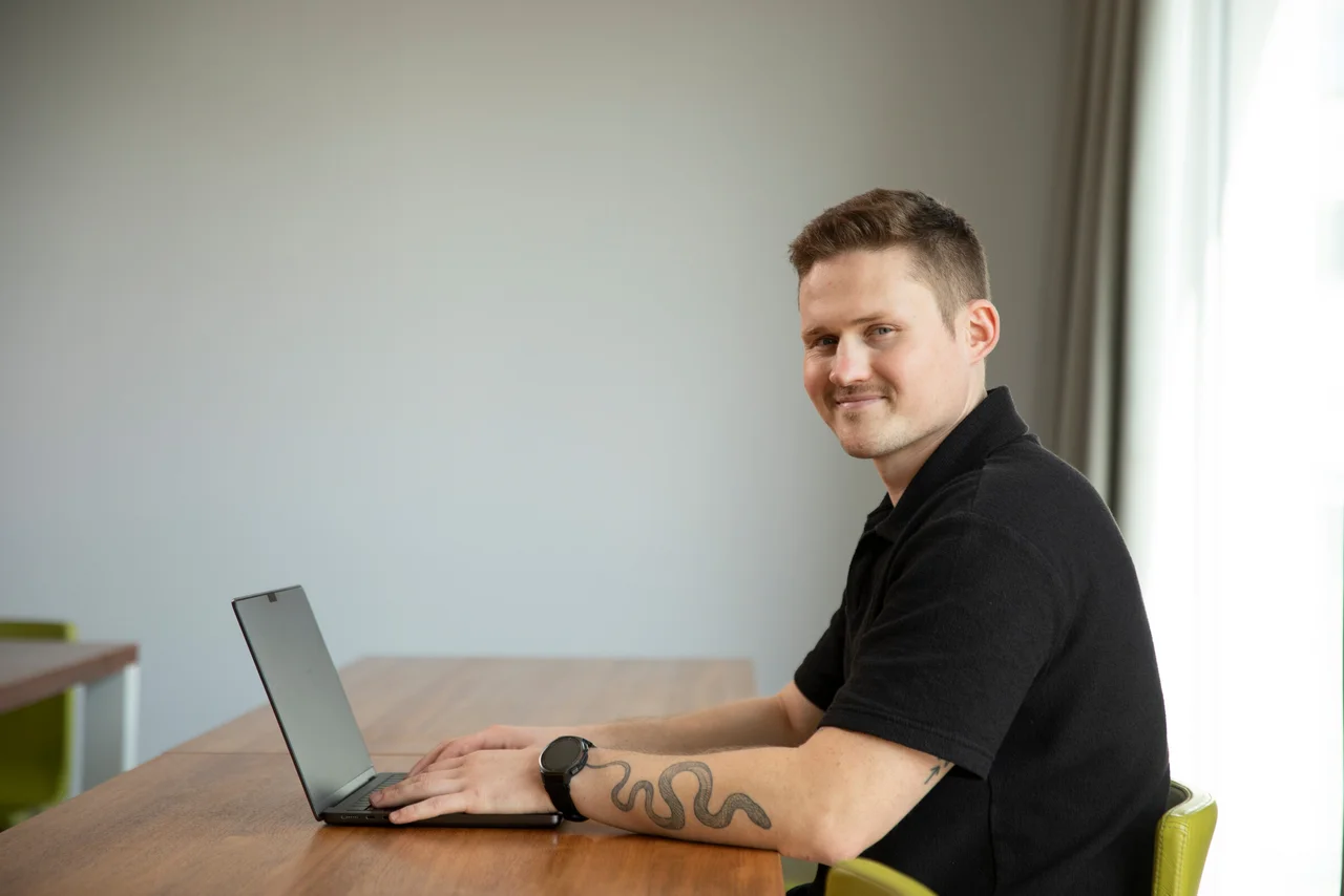 Tim Schauder am Laptop am Besprechungstisch im Potsdamer Büro