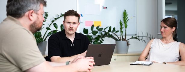 Team bespricht KI-Anwendungsfälle gemeinsam am Laptop